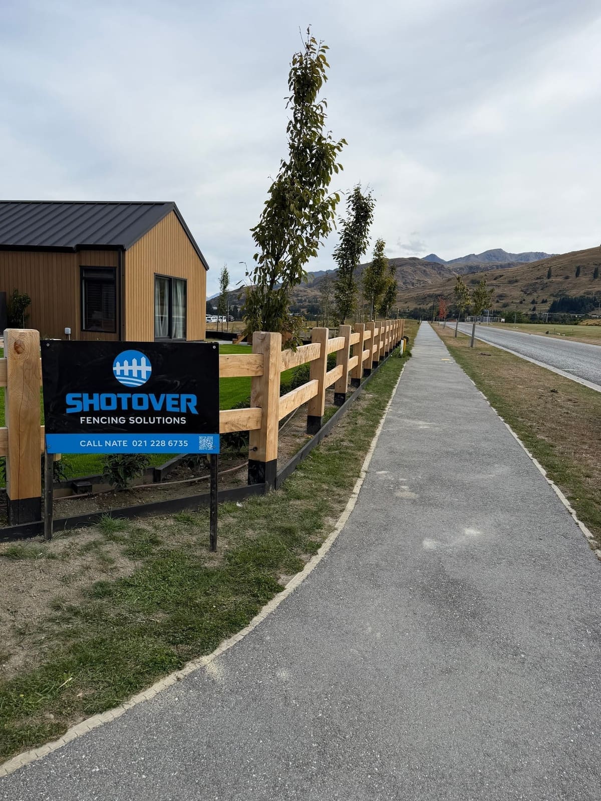 Shotover Fencing Solutions signage with macrocarpa post and rail fencing at a Queenstown subdivision